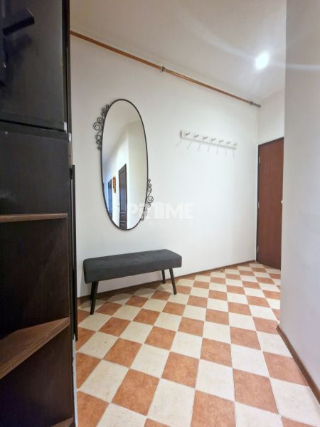 3-Zimmer-Wohnung: Eingangsbereich mit schwarz-weißer Bank, Spiegel und Wandgarderobe.