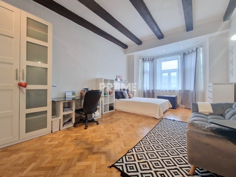 Schlafzimmer in einer 3-Zimmer-Wohnung mit Holzboden und Deckenbalken.