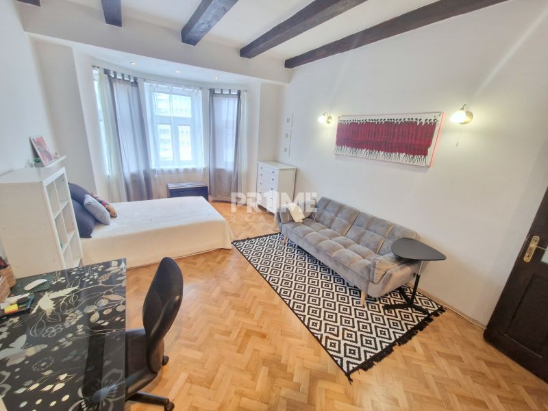 Teilweise möblierte 3-Zimmer-Wohnung mit Sofa, Tisch und Boden in Holzoptik.