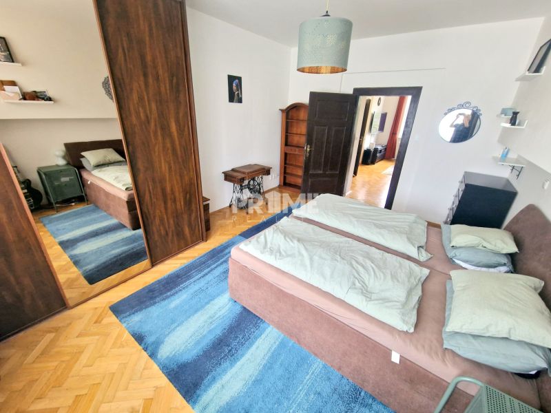 Schlafzimmer in einer 3-Zimmer-Wohnung mit Bett, Spiegelschrank und blauem Teppich.