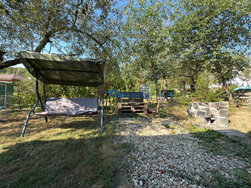 Der Garten bei der Hütte in Vinica in Lučenec mit einer Schaukel und einem gepflegten Weg.