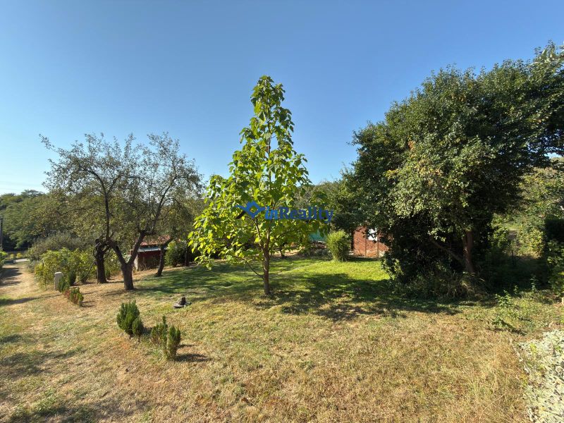 Der Garten bei der Hütte in der Vinica-Straße in Lučenec, voller Bäume und grünem Rasen.