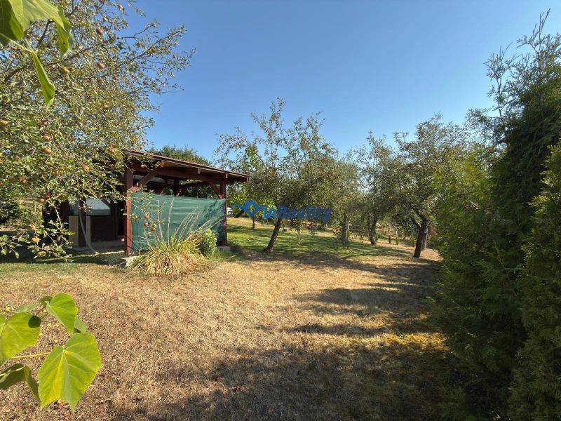 Ein Garten mit einer Hütte, umgeben von Bäumen, in der Straße Vinica in Lučenec.