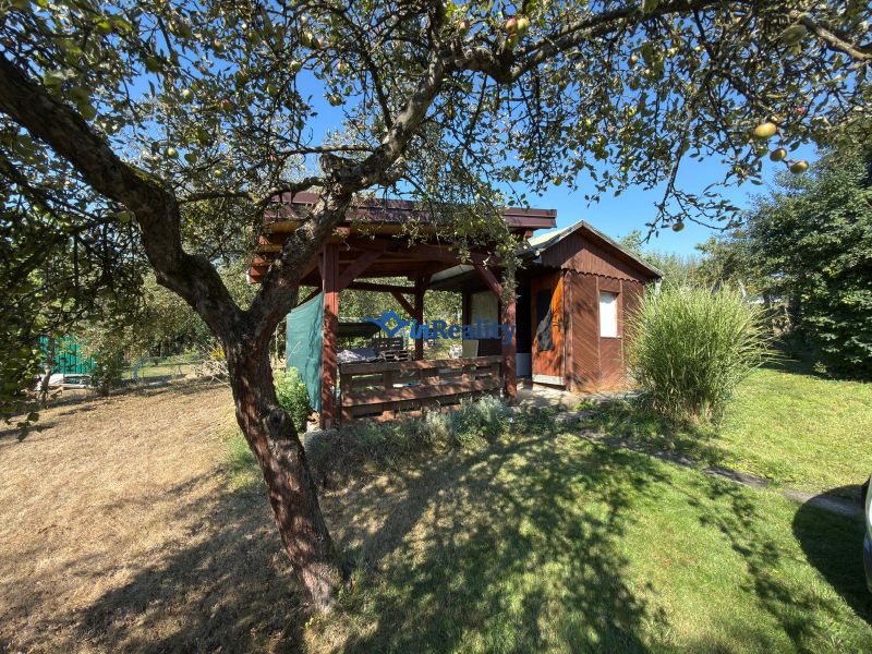 Ein Ferienhaus im Weinberg in Lučenec, umgeben von Grün und Obstbäumen.