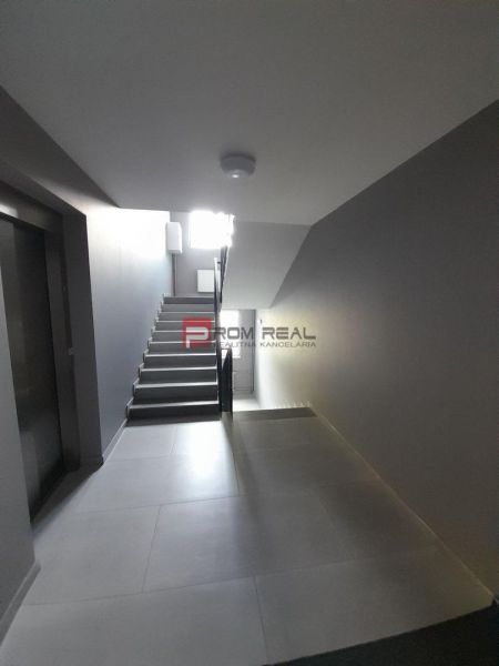 Flur mit Treppe und Aufzug in einer 2-Zimmer-Wohnung.
