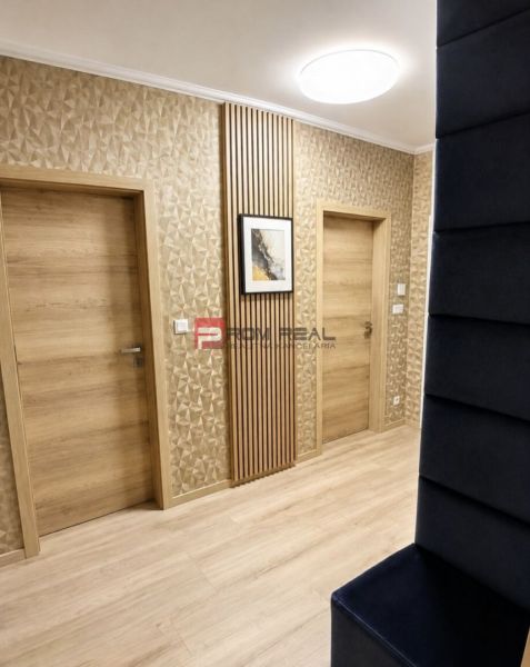 Flur in einer 2-Zimmer-Wohnung mit texturierter Wand und Boden in Holzoptik.