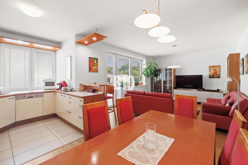 Wohnzimmer mit Küche in einer 4-Zimmer-Wohnung und einem Boden mit Holzdekor.