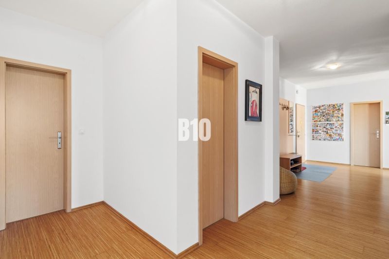 Der Flur in der 4-Zimmer-Wohnung mit einem Boden in Holzoptik und hellen Wänden.