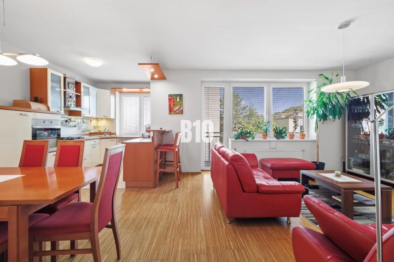 Wohnzimmer in einer 4-Zimmer-Wohnung mit rotem Sofa und Holzboden.