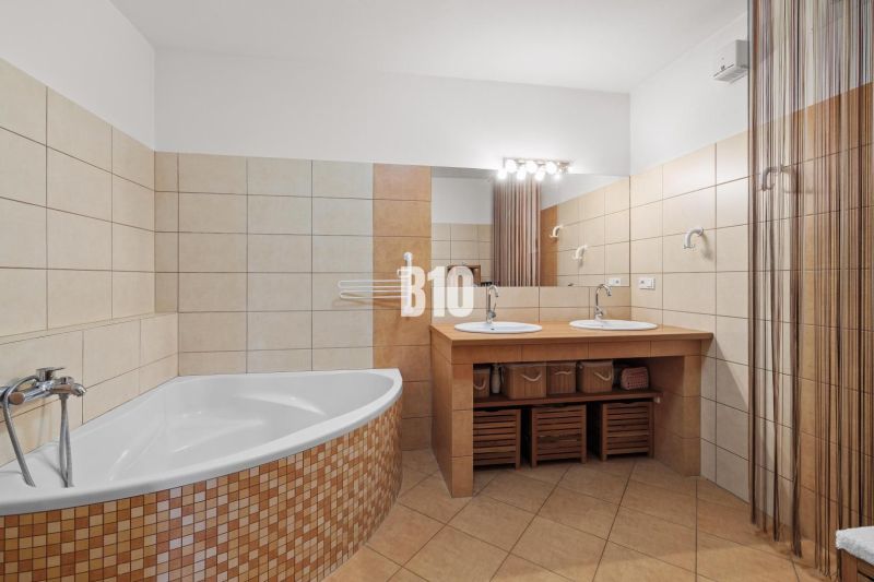 Badezimmer mit separater Badewanne und Doppelwaschbecken in einer 4-Zimmer-Wohnung.