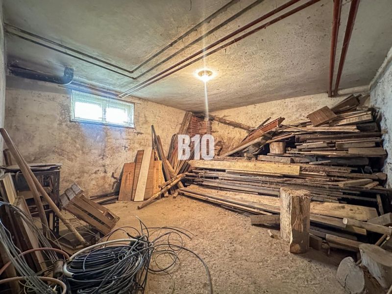 Der Keller eines Einfamilienhauses mit gelagertem Holz und Kabeln.