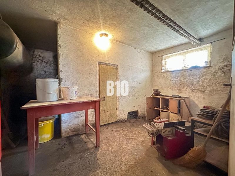 Der Keller eines Einfamilienhauses mit Möbeln und Eimern auf dem Tisch.
