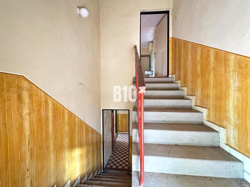 Treppe mit Geländer und Wänden mit Holzdekor in einem Einfamilienhaus.