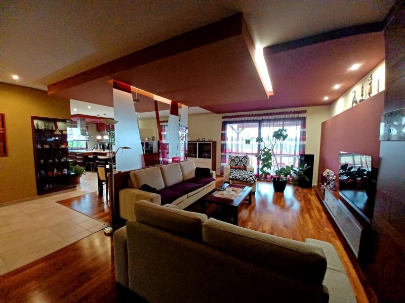 Wohnzimmer in einem Einfamilienhaus mit Holzboden und bequemen Sitzgelegenheiten.