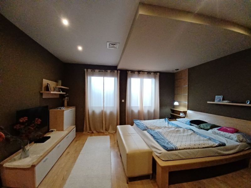 Schlafzimmer mit Bett, Holzboden und komfortabler Einrichtung in einem Einfamilienhaus.