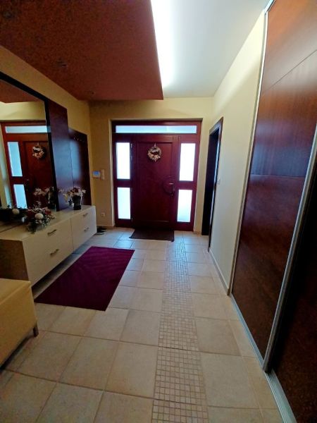 Eingangsbereich in einem Einfamilienhaus mit Fliesen und einem Schrank, ergänzt durch Dekorationen.