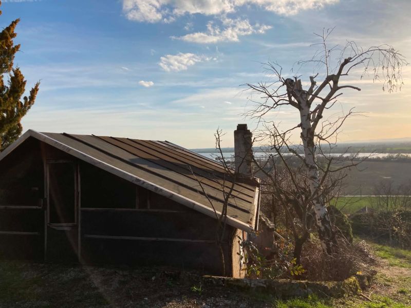 Eine Hütte in den Bergen mit Blick auf die Landschaft und Bäumen in der Umgebung.
