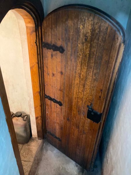 Alte Holztüren in der Hütte mit sichtbarem Kanister im engen Raum.