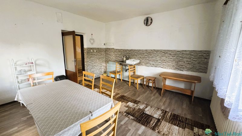Esszimmer in einem Einfamilienhaus mit Holzboden, einfachem Möbel und Waschbecken.
