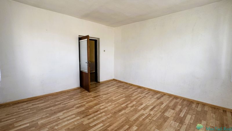 Ein Zimmer in einem Einfamilienhaus mit Holzboden und offenen Türen.