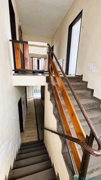 Eine Treppe im Einfamilienhaus mit einem Holzgeländer und einem Teppich auf den Stufen.