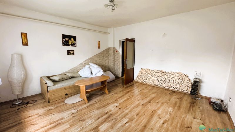 Wohnzimmer in einem Einfamilienhaus mit Sofa und Boden in Holzoptik.