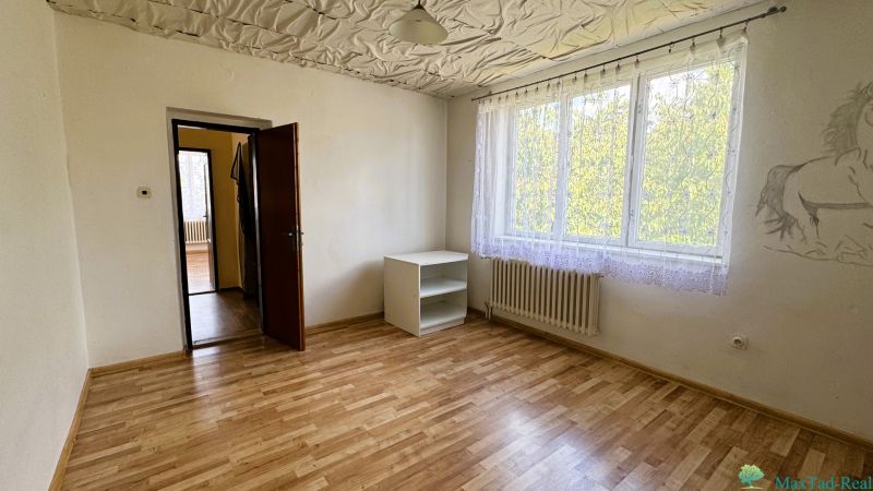 Ein Zimmer mit einem Holzboden, einem Schrank und einem Wandgemälde in einem Einfamilienhaus.