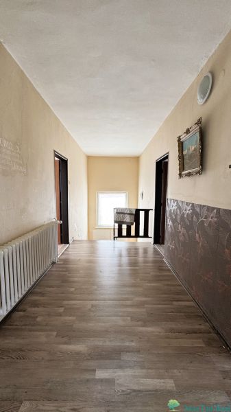 Ein Flur in einem Einfamilienhaus mit einem Boden in Holzoptik, dekorativen Wänden und einem Heizkörper.