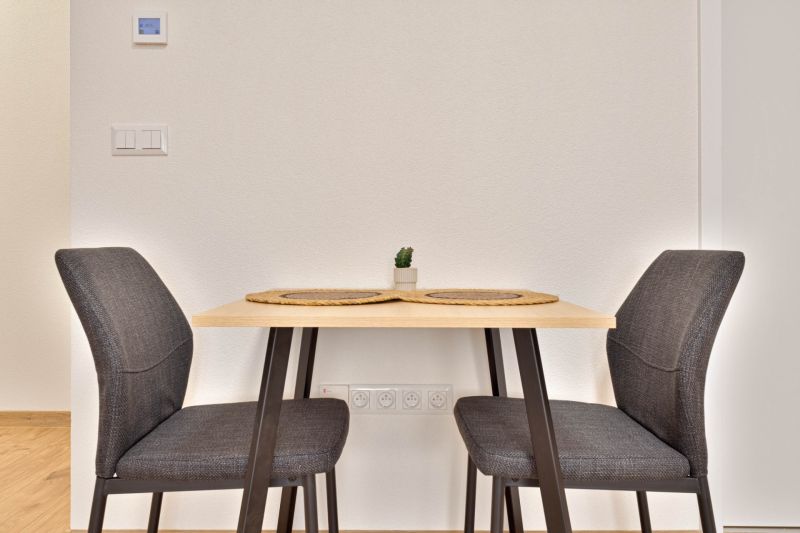 Essbereich mit einem Tisch und zwei Stühlen in einer Einzimmerwohnung.