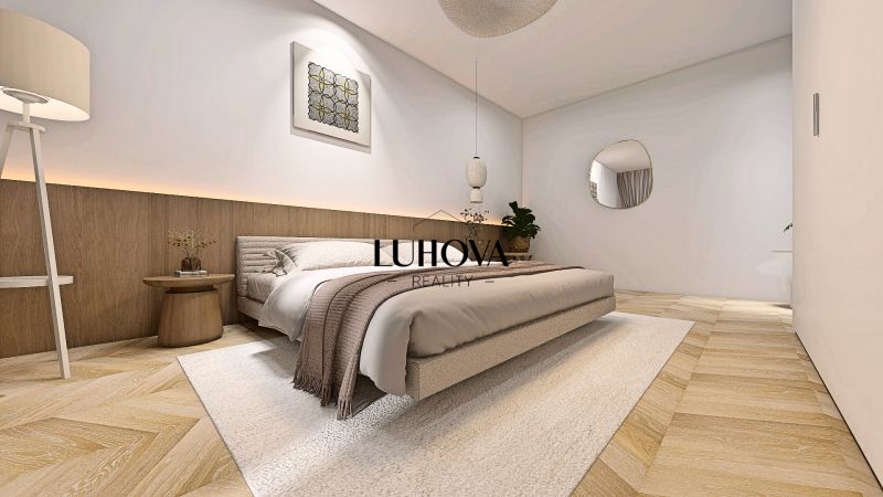 Schlafzimmer in einer 2-Zimmer-Wohnung mit neutralen Tönen und einem Holzboden.