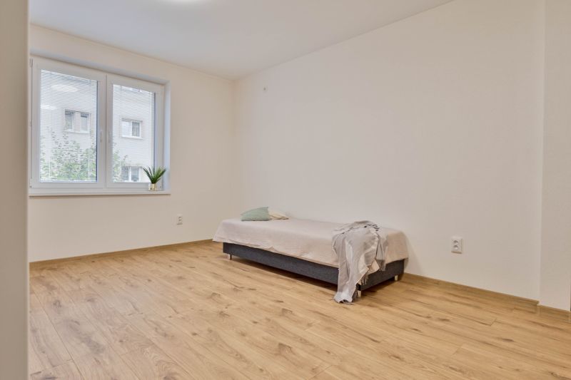 Einzimmerwohnung mit Bett, Holzboden und Fenster mit Aussicht.