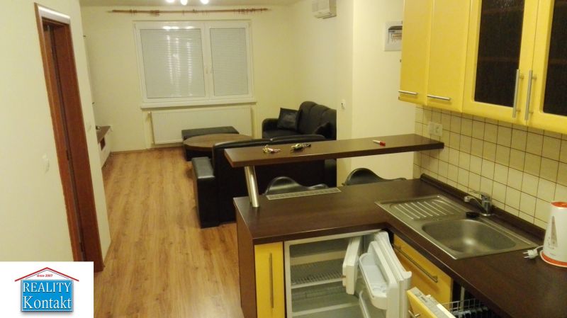 Küche in einer 3-Zimmer-Wohnung mit Holzboden und Sofa.