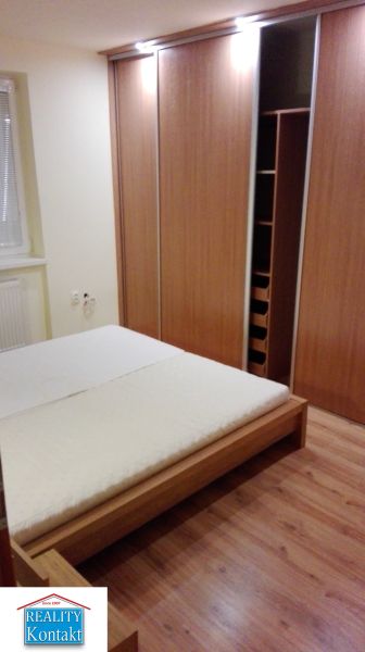 Schlafzimmer mit Holzboden und Einbauschrank in einer 3-Zimmer-Wohnung.