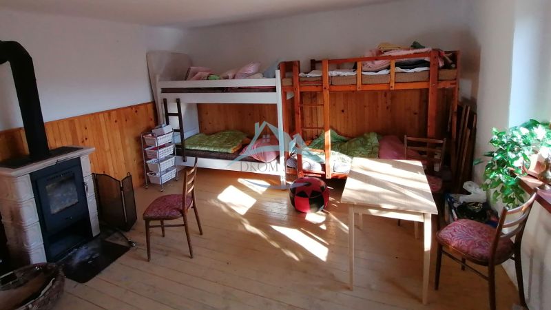 Etagenbetten, Kaminofen und Möbel im Zimmer eines Einfamilienhauses.