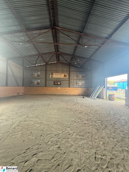 Das Innere des Gebäudes mit Sandboden und Metalldach.