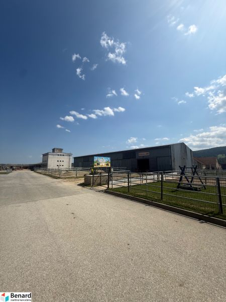 Industriegebäude in Hniezdne mit klarem blauen Himmel und Zufahrtsstraße.