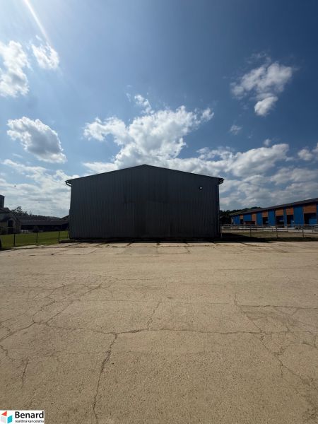 Ein Gebäude in Hniezdne mit einem großen befestigten Platz und blauem Himmel.