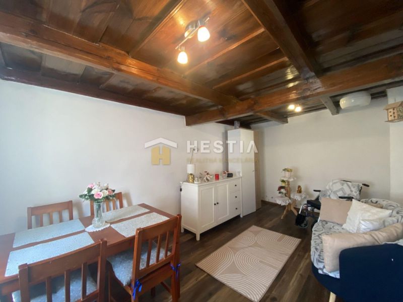 Wohnzimmer in einem Einfamilienhaus mit Möbeln und Boden in Holzoptik.