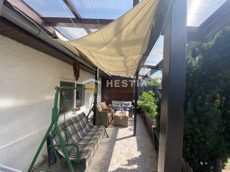 Die Terrasse des Einfamilienhauses in Borský Mikuláš mit Überdachung und Gartenschaukel.