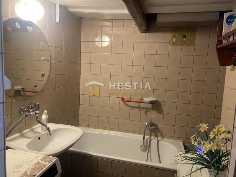 Badezimmer mit Badewanne, Waschbecken und Spiegel mit Dekoration in einem Einfamilienhaus.