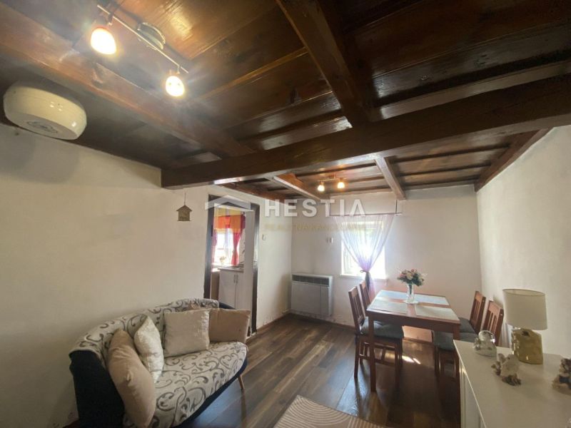 Wohnzimmer in einem Einfamilienhaus mit Holzdecke und Boden in Holzoptik.