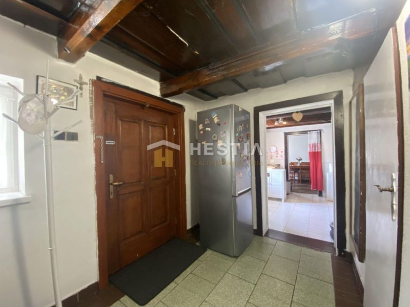 Interieur eines Einfamilienhauses mit Holzbalkendecke, Flur und Küche.