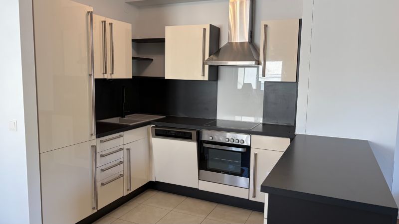Küche in einer 3-Zimmer-Wohnung, mit passender schwarz-weißer Küchenzeile und Geräten.