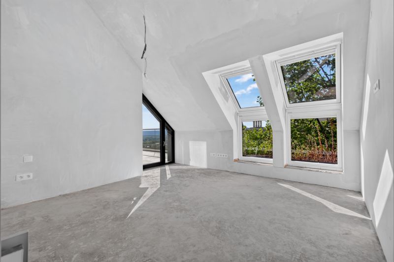 Dachgeschosszimmer mit großen Fenstern in einer Wohnung mit 5 oder mehr Zimmern, weiße Wandfarbe.