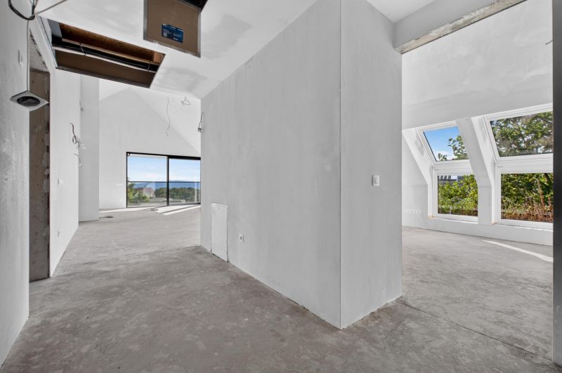 Ein geräumiges Interieur mit großen Fenstern in einer Wohnung mit 5 oder mehr Zimmern.