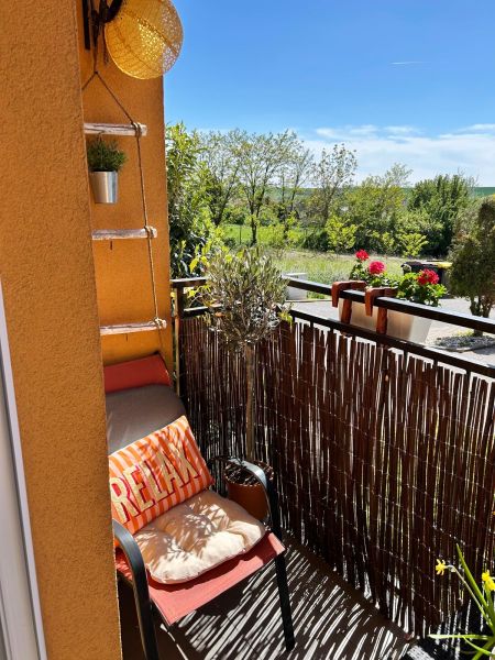 Ein Balkon in einer 3-Zimmer-Wohnung mit einem bequemen Sessel und Blick ins Grüne in Veľký Lapáš.