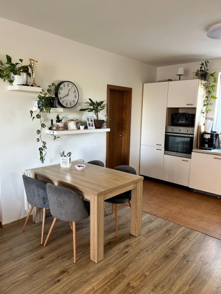 Küche in einer 3-Zimmer-Wohnung mit Wandregalen und einem Boden in Holzoptik.