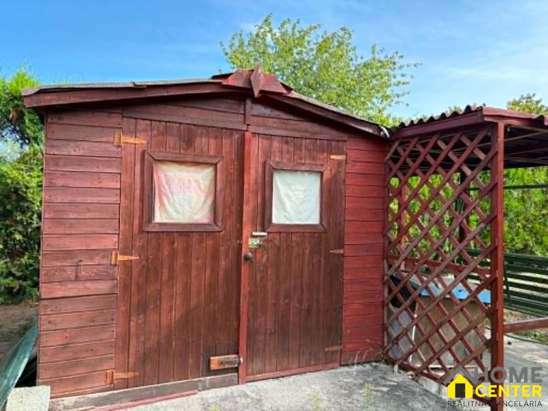 Holzgartenhaus mit überdachtem Unterstand in den Gärten von Komárno.