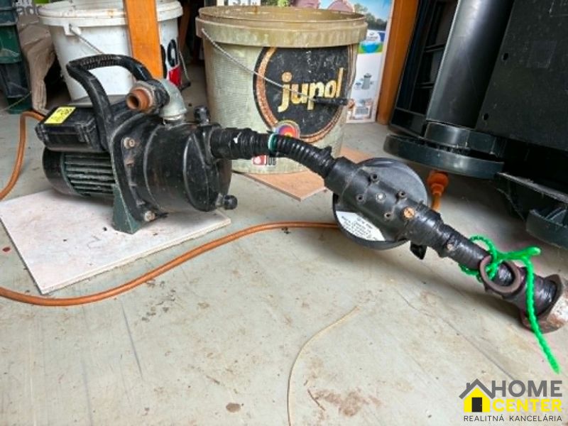 Pumpe und Schlauch auf dem Boden mit Holzdekor in den Gärten.