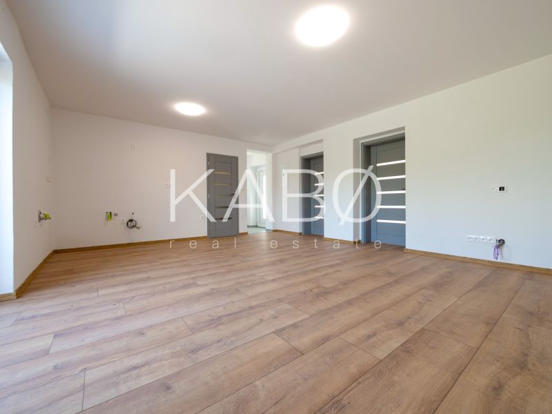 Wohnzimmer in einem Einfamilienhaus mit Holzboden und weißen Wänden.